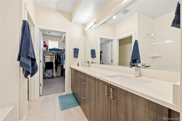 full bathroom with a sink, tile patterned flooring, double vanity, a shower, and visible vents
