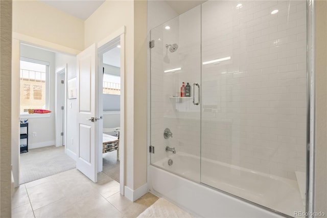 bathroom with baseboards, bath / shower combo with glass door, and tile patterned floors
