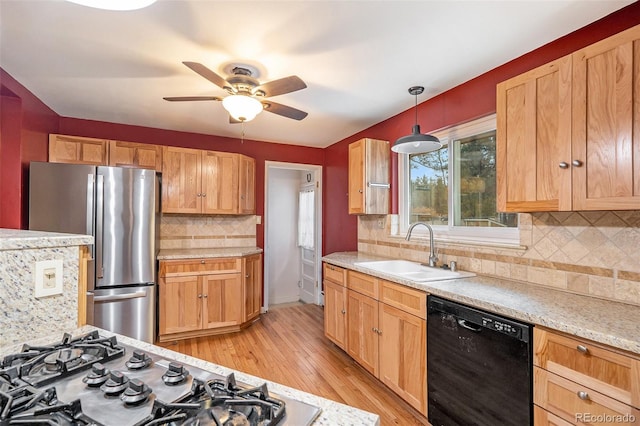 kitchen with tasteful backsplash, hanging light fixtures, appliances with stainless steel finishes, light hardwood / wood-style floors, and sink