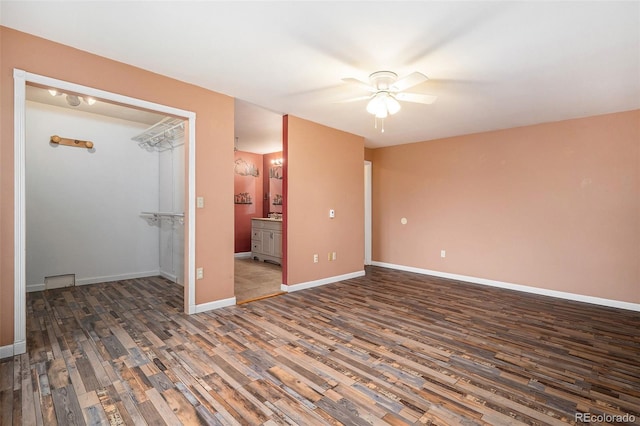 unfurnished bedroom featuring ceiling fan, ensuite bath, and dark hardwood / wood-style flooring