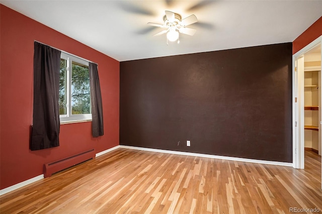 unfurnished room featuring light hardwood / wood-style floors, baseboard heating, and ceiling fan