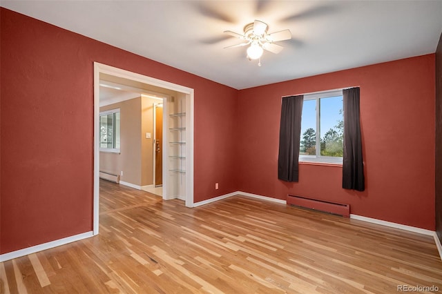 empty room with light hardwood / wood-style floors, a baseboard radiator, and ceiling fan