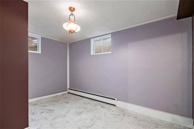 spare room with a textured ceiling, baseboard heating, and a wealth of natural light