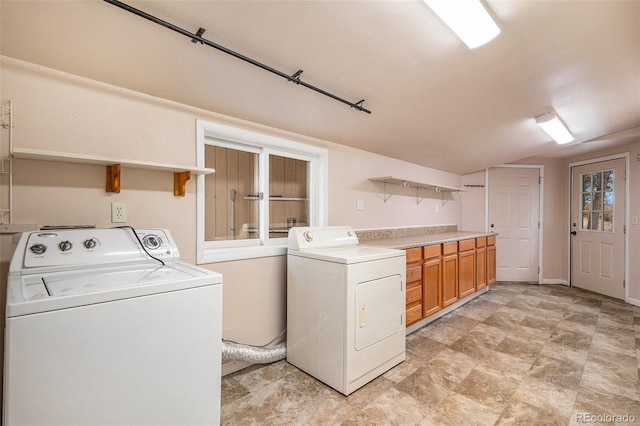 clothes washing area with cabinets and independent washer and dryer