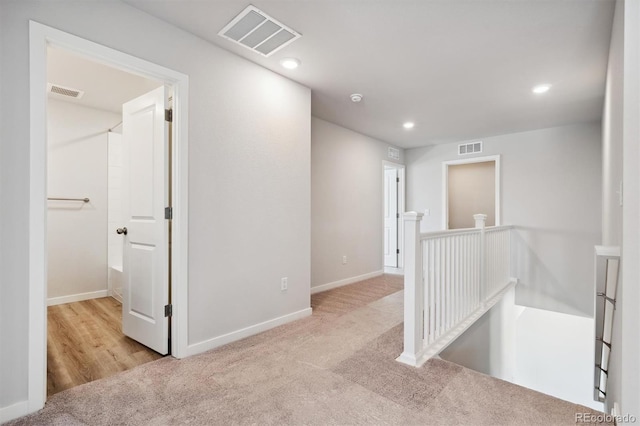 hallway with light colored carpet