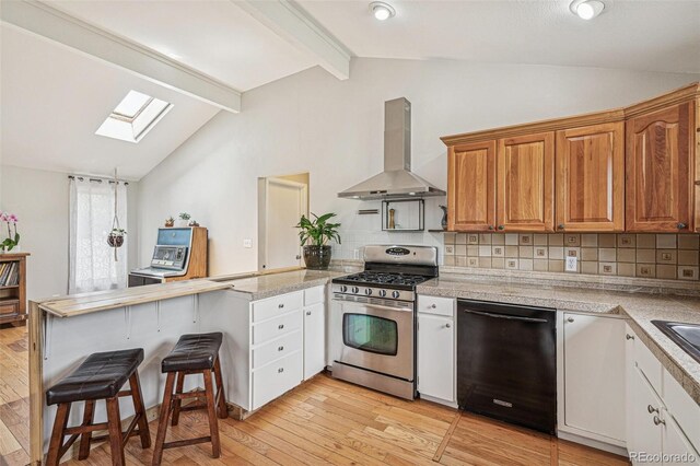280 Pierce St, Erie, CO 80516 - kitchen featuring stainless steel gas range oven, wall chimney exhaust hood, black dishwasher, a peninsula, and a skylight