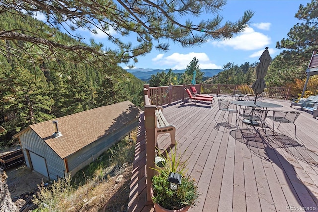 deck with a mountain view and outdoor dining space