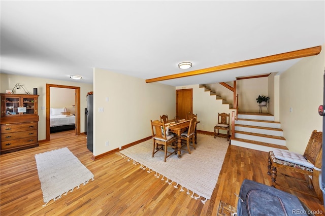 dining area with stairs, light wood-type flooring, and baseboards