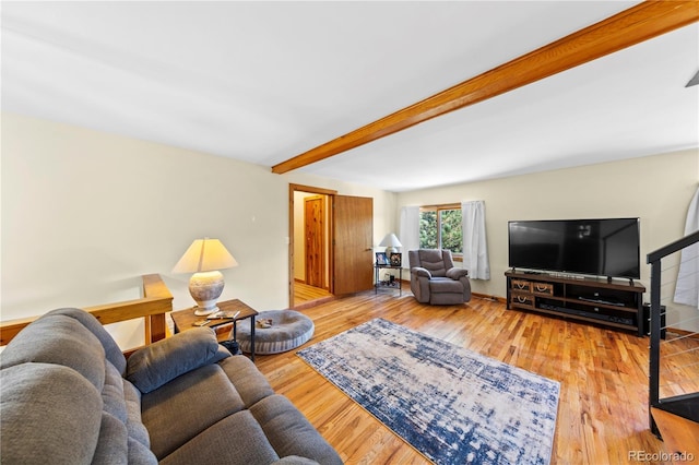 living area with beamed ceiling and wood finished floors