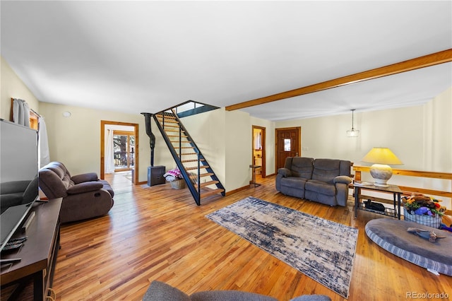 living area featuring stairs, wood finished floors, and baseboards