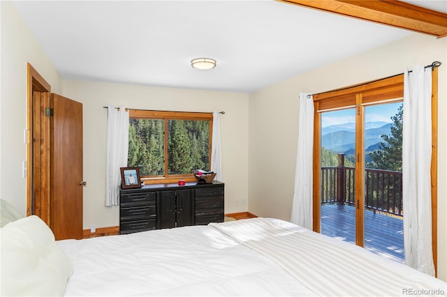 bedroom with access to exterior and baseboards