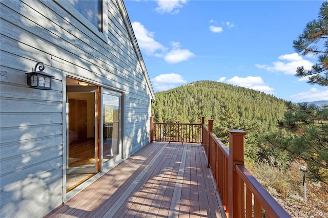 deck featuring a wooded view and a mountain view