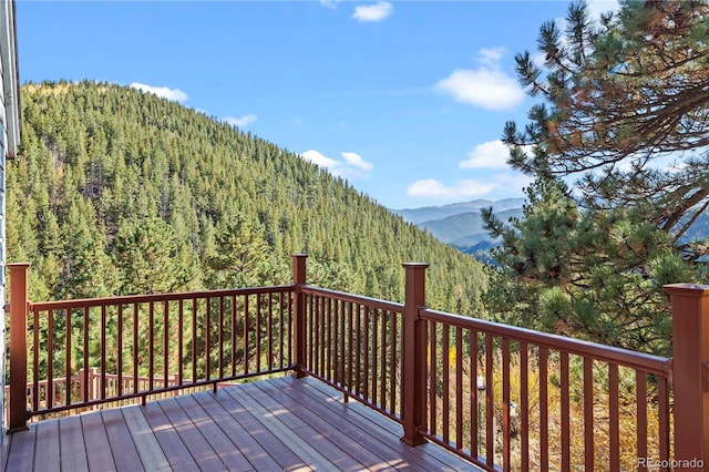 wooden terrace featuring a view of trees and a mountain view