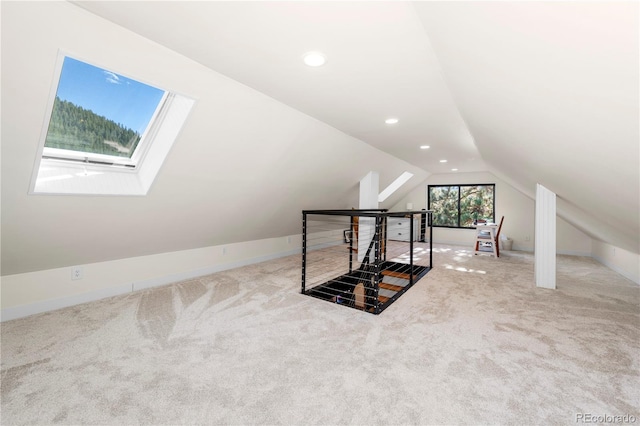 bonus room featuring lofted ceiling with skylight and carpet flooring