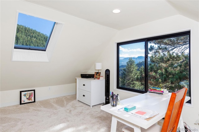 office area with light carpet and lofted ceiling with skylight