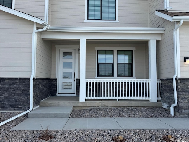 view of exterior entry featuring covered porch