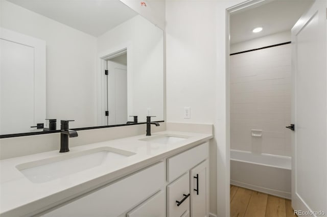 bathroom featuring shower / tub combination, wood-type flooring, and vanity