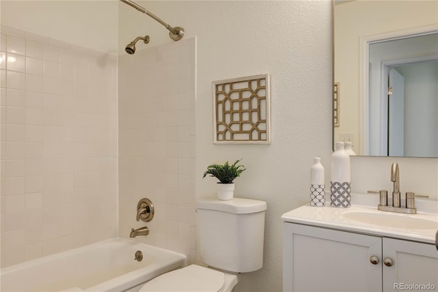 full bathroom with tiled shower / bath, vanity, and toilet