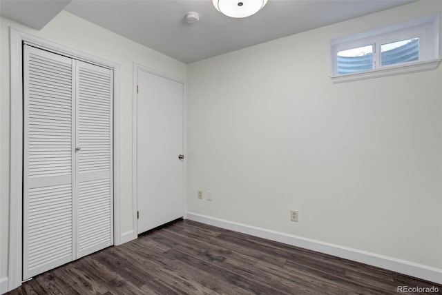 unfurnished bedroom with dark hardwood / wood-style floors and a closet