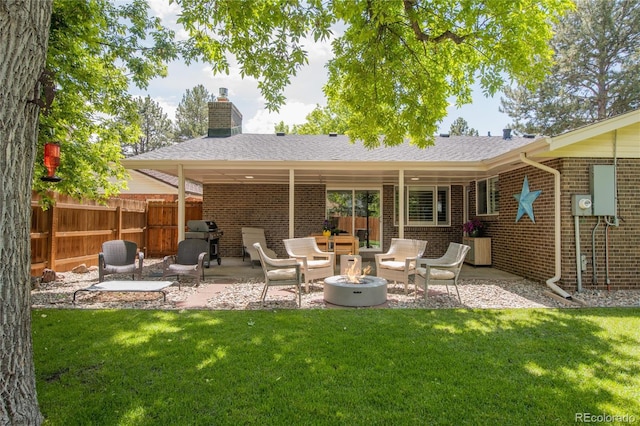9861 E Ohio Ave, Denver, CO 80247 - back of property with brick siding, a fire pit, a chimney, and a patio