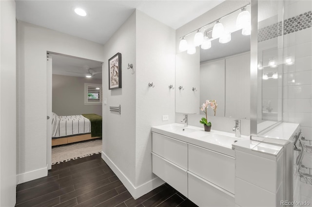 9861 E Ohio Ave, Denver, CO 80247 - full bathroom with baseboards, double vanity, ensuite bath, wood finished floors, and a ceiling fan