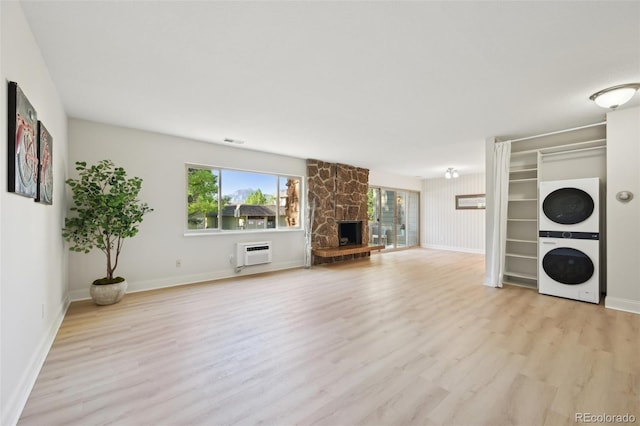 3365 Chisholm Trl Unit B102, Boulder, CO 80301 - unfurnished living room featuring stacked washer / dryer, healthy amount of natural light, light wood-style floors, and baseboards