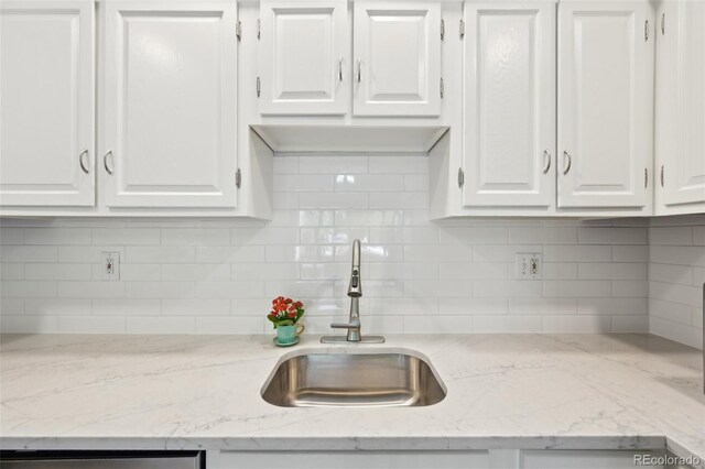 3365 Chisholm Trl Unit B102, Boulder, CO 80301 - kitchen featuring a sink, white cabinets, tasteful backsplash, and light stone countertops