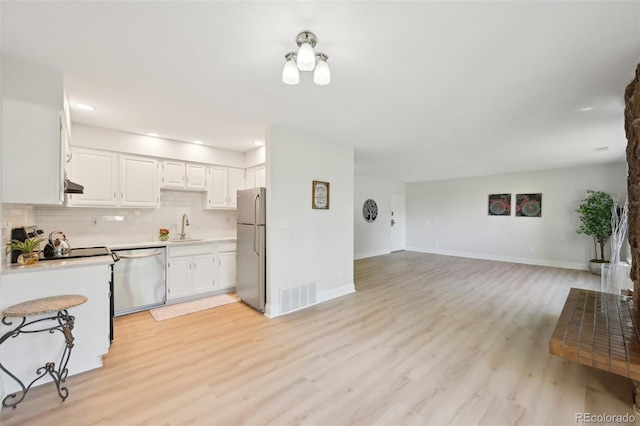 3365 Chisholm Trl Unit B102, Boulder, CO 80301 - kitchen featuring appliances with stainless steel finishes, light countertops, open floor plan, light wood-style floors, and white cabinets