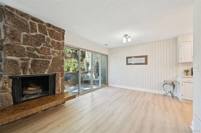3365 Chisholm Trl Unit B102, Boulder, CO 80301 - unfurnished living room featuring light wood-type flooring, a stone fireplace, and baseboards