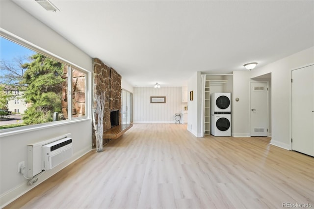 3365 Chisholm Trl Unit B102, Boulder, CO 80301 - unfurnished living room with estacked washer and dryer, wood finished floors, a stone fireplace, and a wall mounted AC