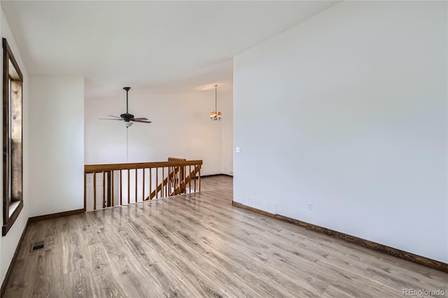 empty room with wood finished floors, baseboards, and a ceiling fan
