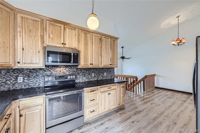 kitchen featuring stainless steel appliances, tasteful backsplash, dark countertops, a chandelier, and vaulted ceiling