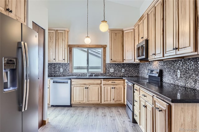 kitchen featuring stainless steel appliances, a sink, light brown cabinetry, light wood finished floors, and backsplash