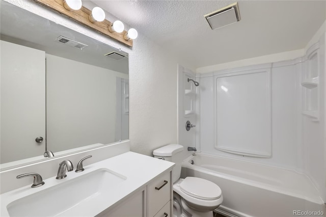 full bathroom featuring vanity, toilet, a textured wall,  shower combination, and a textured ceiling