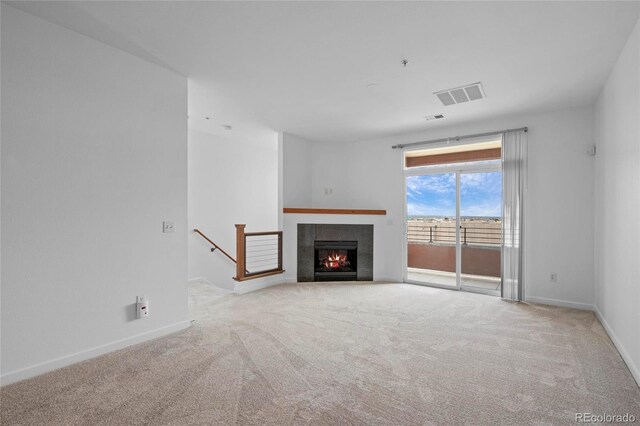 4100 Albion St Unit 320, Denver, CO 80216 - unfurnished living room featuring carpet flooring and a warm lit fireplace