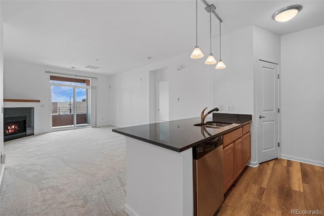 4100 Albion St Unit 320, Denver, CO 80216 - kitchen featuring dishwasher, dark countertops, a lit fireplace, pendant lighting, and a peninsula