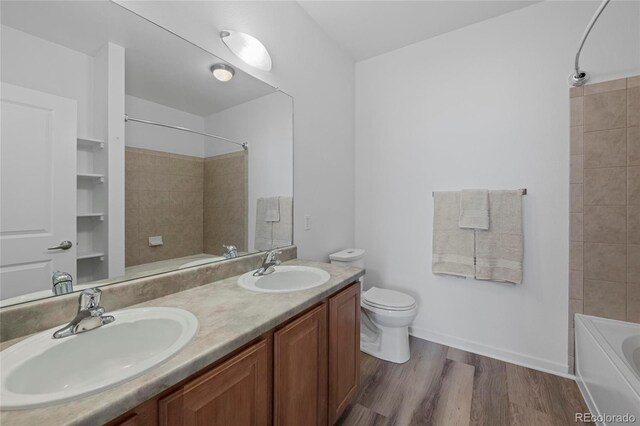 4100 Albion St Unit 320, Denver, CO 80216 - bathroom featuring shower / bathtub combination, double vanity, and wood finished floors