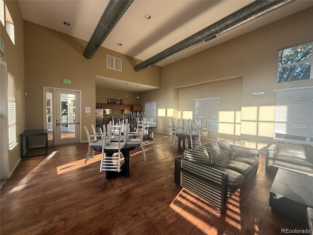 4100 Albion St Unit 320, Denver, CO 80216 - living area featuring a towering ceiling, wood finished floors, and healthy amount of natural light