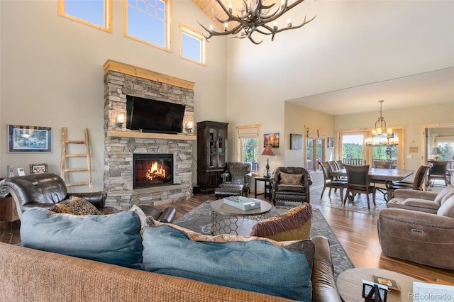 632 Gcr 662, Grand Lake, CO 80447 - living area featuring an inviting chandelier, a high ceiling, a fireplace, and wood finished floors