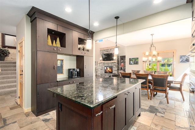 632 Gcr 662, Grand Lake, CO 80447 - kitchen with stone tile floors, pendant lighting, dark brown cabinets, a fireplace, and recessed lighting