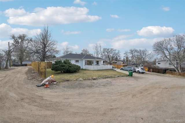 view of front of property with driveway, a front yard, and fence