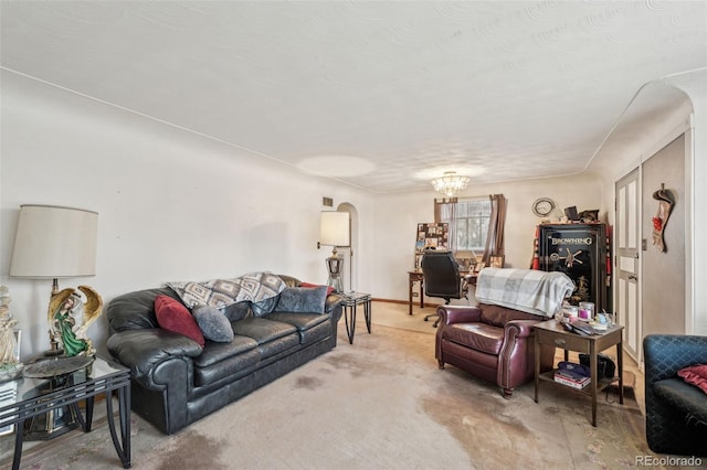 carpeted living area featuring arched walkways and an inviting chandelier