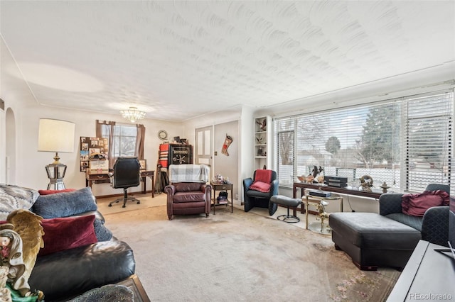 living area with built in features, arched walkways, and carpet floors