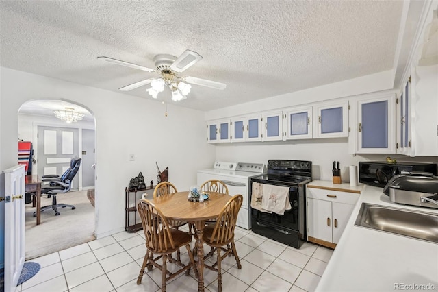 dining area featuring washing machine and clothes dryer, ceiling fan with notable chandelier, light tile patterned flooring, arched walkways, and a textured ceiling