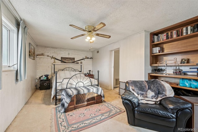 carpeted bedroom with visible vents, a textured ceiling, brick wall, and a ceiling fan