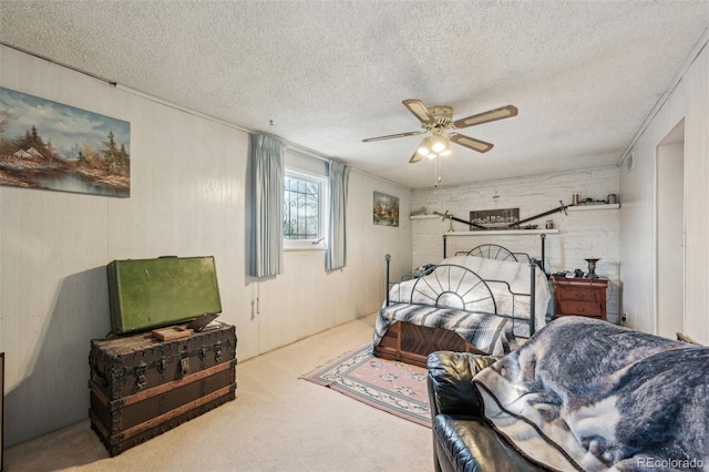 bedroom with carpet flooring, brick wall, a textured ceiling, and ceiling fan