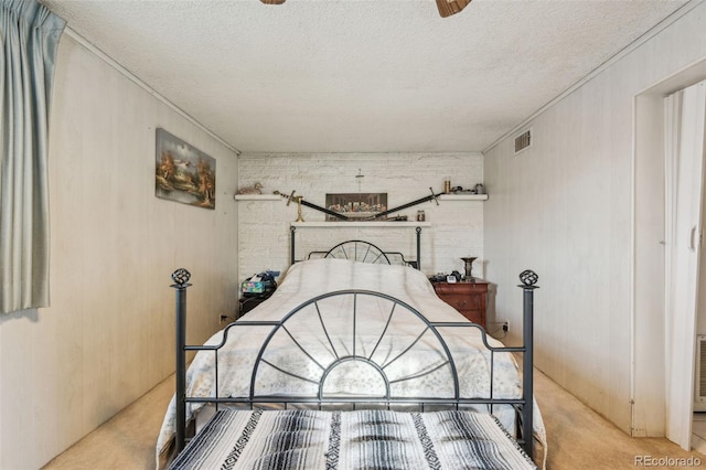 bedroom with visible vents, carpet, brick wall, and a textured ceiling