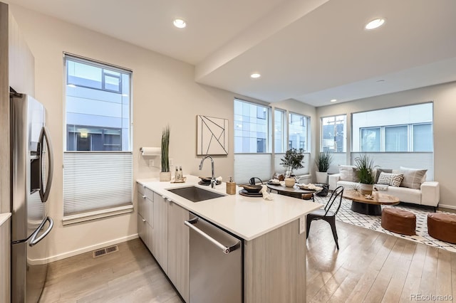 3256 Federal Blvd, Denver, CO 80211 - kitchen featuring stainless steel appliances, a peninsula, open floor plan, light wood-style floors, and light countertops