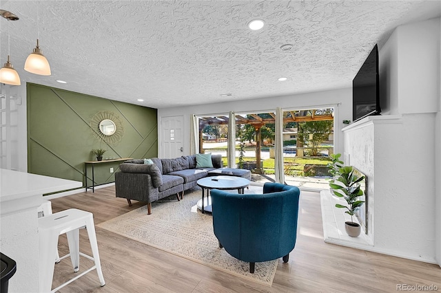 living room featuring light hardwood / wood-style flooring and a textured ceiling