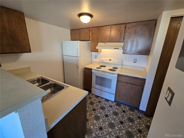 kitchen with white appliances, light countertops, a sink, and under cabinet range hood